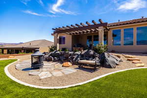 Back of house featuring a patio, stucco siding, a pergola, and a yard