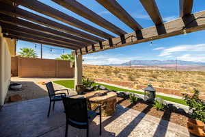 Fenced backyard with a pergola, a fire pit, a patio area, and a mountain view