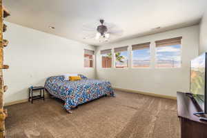 Master Suite with carpeted bedroom with baseboards and ceiling fan