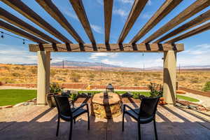 View of patio featuring a pergola, a mountain view, a desert view, an outdoor fire pit, and a rural view