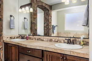 Bathroom featuring double vanity and tasteful backsplash