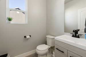 Half bath featuring baseboards and vanity