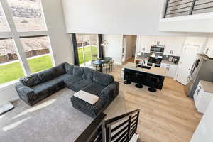 Living room featuring a towering ceiling and light wood-style flooring