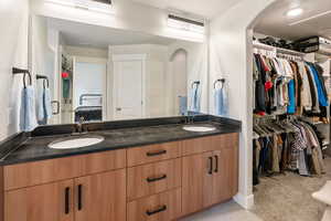 Bathroom featuring double vanity and a spacious closet