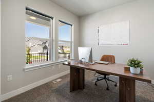 Office space featuring dark carpet and a residential view