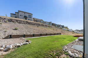 View of green lawn with a residential view