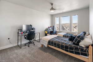 Bedroom featuring carpet floors, a ceiling fan, and an office area