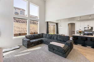 Living room with arched walkways, a high ceiling, and a chandelier