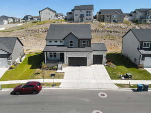 Modern farmhouse with a residential view, driveway, a shingled roof, and an attached garage