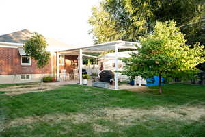 Back of house featuring a patio area, a lawn.