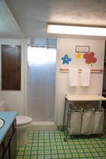 2nd Bathroom with a textured ceiling, a stall shower, and vanity