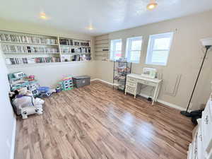 Recreation room featuring a textured ceiling, light wood-style floors, and recessed lighting