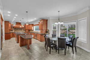 Dining area with ornamental molding, light tile patterned floors, recessed lighting, and a chandelier