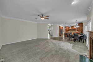 Living area with healthy amount of natural light, crown molding, light tile patterned flooring, recessed lighting, and ceiling fan
