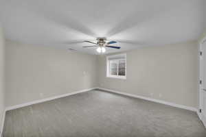 Spare room with light colored carpet, a textured ceiling, and a ceiling fan