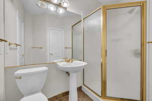 Bathroom featuring a stall shower and toilet