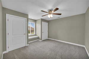 Unfurnished bedroom with carpet floors, a textured ceiling, and a ceiling fan