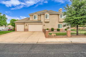 Traditional home with a chimney, stucco siding, driveway, an attached garage, and a tile roof