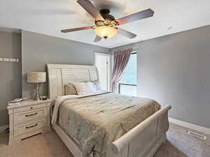 Carpeted bedroom with a textured ceiling and a ceiling fan