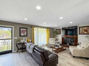 Living room with wood finished floors, a textured ceiling, recessed lighting, and wooden walls