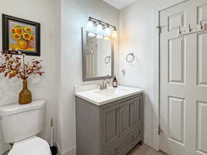 Half bathroom featuring vanity and toilet