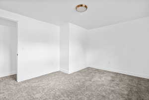 Carpeted empty room with baseboards and a textured ceiling