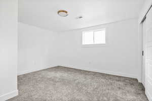 Unfurnished bedroom with light carpet, a closet, and a textured ceiling