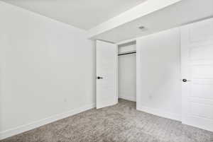 Unfurnished bedroom with carpet, a textured ceiling, and a closet