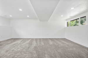 Empty room featuring light colored carpet, a textured ceiling, and recessed lighting