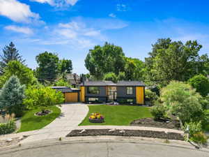 Bi-level home with a metal roof, a front lawn, and a standing seam roof