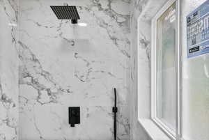 Bathroom featuring a marble finish shower