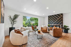 Living area with light wood finished floors and recessed lighting