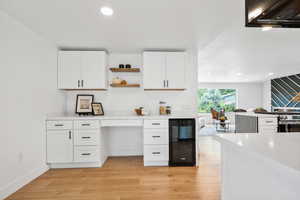 Kitchen with white cabinetry, beverage cooler, open shelves, light wood-type flooring, and recessed lighting