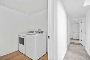 Laundry room featuring washer and dryer and light wood-type flooring