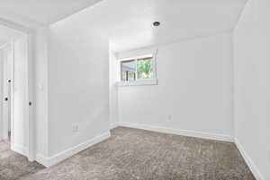 Carpeted spare room featuring baseboards and a textured ceiling