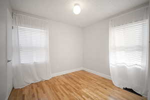 Third bedroom with light wood-style floors and ornamental molding