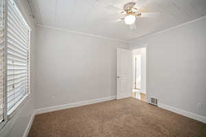 Carpeted Master bedroom with crown molding and ceiling fan