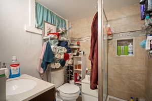 Bathroom featuring vanity, a shower stall, and a textured wall