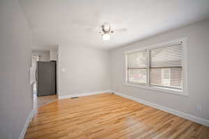 Living room with light wood-type flooring and ceiling fan