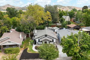 Aerial view of residential area featuring mountains and a tree filled landscape