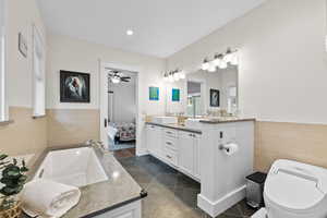 Full bathroom featuring double vanity, separate tub/shower, and lots of natural light