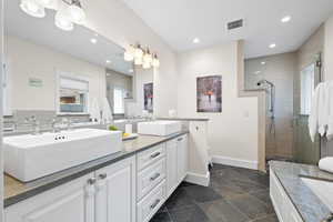 Bathroom with double vanity, separate tub and shower, and heated floors