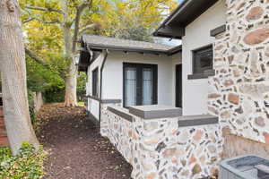 View of side of property with stucco and stone siding, french doors to patio