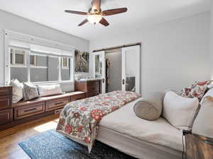 Primary bedroom featuring dark wood finished floors, walk-in closet