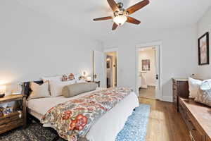 Primary bedroom featuring dark wood flooring, built-in bench seating, and ensuite bath