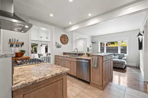 Kitchen with beam ceiling, granite countertops, and stainless steel appliances