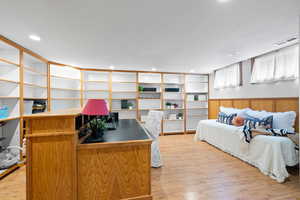 Bedroom 4 with light wood-style flooring and recessed lighting and built in shelving