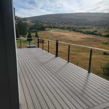 Wooden deck featuring a lawn and a rural view
