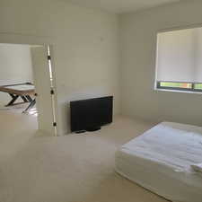 Bedroom with light colored carpet and baseboards