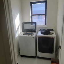 Laundry room featuring plenty of natural light, light tile patterned floors, and independent washer and dryer